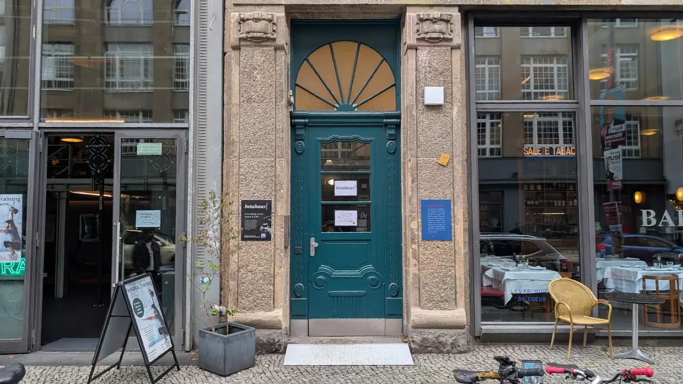 The street entrance to betahaus Kreuzberg: a teal door between stone pillars on Rudi-Dutschke-Straße